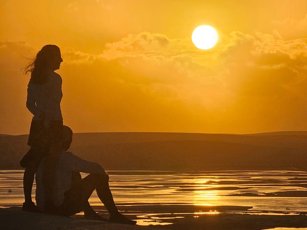 Couple watching the sunset at Lencois Maranhenses